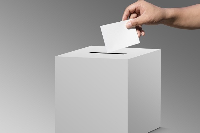 Abstimmungszette wird in die Wahlurne geworfen