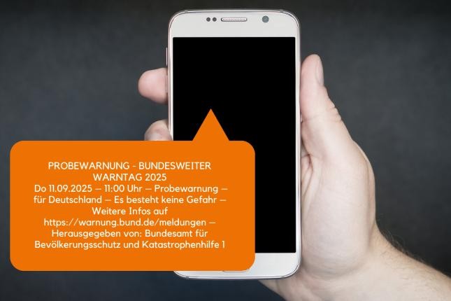 Handy in einer Hand mit Informationen zum Warntag Handy in einer Hand mit Informationen zum Warntag