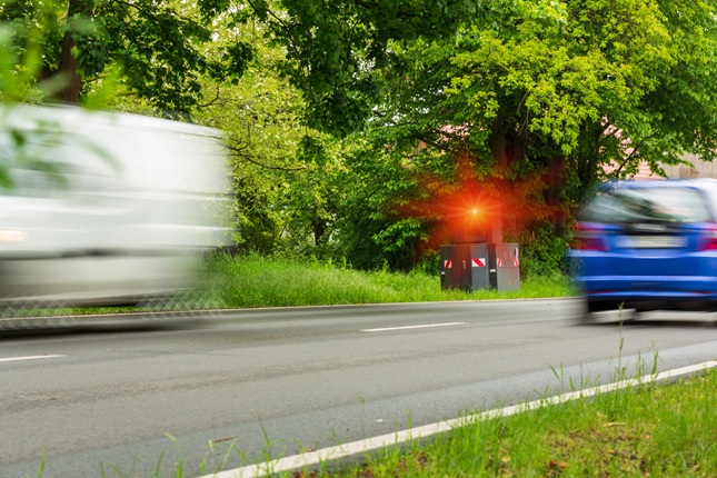 Blitzer der auslöst sowie zwei Autos Blitzer der auslöst sowie zwei Autos